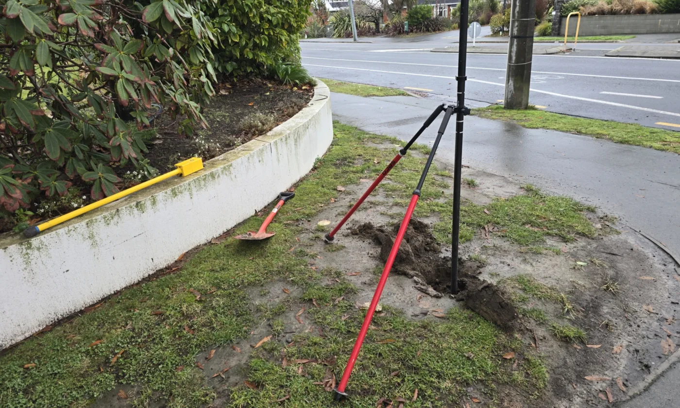 An Eliot Sinclair survey marker denoting the corner boundary of a residential New Zealand property.